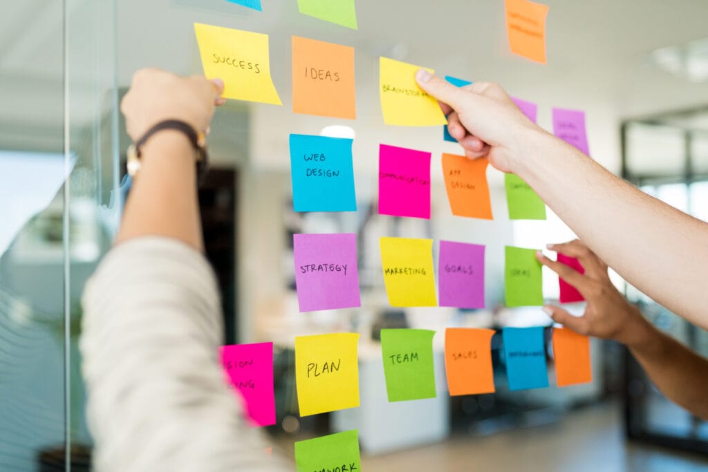 business people arranging various adhesive notes with text glass office scaled 1 business people arranging various adhesive notes with text glass office scaled 1
